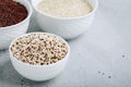 Quinoa. Red white brown quinoa seeds in bowl. Mixed raw quinoa seeds on gray stone background Royalty Free Stock Photo