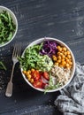 Quinoa and spicy chickpea vegetable vegetarian buddha bowl. Healthy food concept. On a dark background