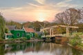 Quintessential Dutch village with traditional green wooden houses, windmill and drawbridge