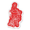 quirky cartoon distressed sticker of a cat with christmas present wearing santa hat