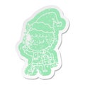 quirky cartoon distressed sticker of a grumpy boy wearing santa hat