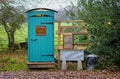 Quirky outside wooden toilet and wash basin in woodland setting at Marston Park, Somerset, UK