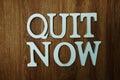 Quit Now word alphabet letters on wooden background