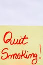 Quit smoking handwriting text close up isolated on yellow paper with copy space