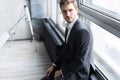 Quite contemplation. Thoughtful man in full suit looking away through the window while standing indoors. Royalty Free Stock Photo