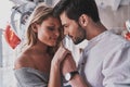 Quite moments together. Beautiful young couple holding hands while standing in the bedroom full of balloons Royalty Free Stock Photo