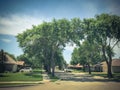 Quite neighborhood with tall trees canopy, pathway and single family houses lined up Royalty Free Stock Photo