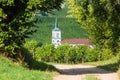 A quite road leading towards a French church and beautiful forest in the Alsace