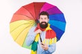 Quite useful for keeping him dry. Rain man. Bearded man with colorful umbrella. Colorful person holding open umbrella