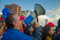 Quito, Ecuador - April 7, 2016: Unknown opposition protester with megaphone surrounded by people, police and journalists