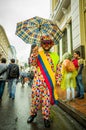 Quito, Ecuador - August 27, 2015: Man dressed up as a clown with umbrella in city streets during mass demonstrations Royalty Free Stock Photo