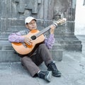 Local Ecuadorian older man plays guitar on the street