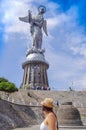 Quito, Ecuador, December, 12 2018: Unidentified woman in front La Virgin del Panecillo in a gorgeous blue sky