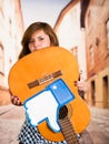 Quito, Ecuador - March 11, 2016: Young woman holding a guitar with a big like hand printed upside down, in a blurred Royalty Free Stock Photo