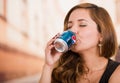 Quito, Ecuador - May 06, 2017: Pretty young woman drinking a pepsi in blurred city background