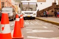 QUITO, ECUADOR NOVEMBER, 28, 2017: Close up of blurred orange cones with a bus and people behind in the historical