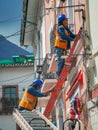 Quito, ECUADOR - 02 October 2019: Electricians are climbing on electric poles to install and repair power lines Royalty Free Stock Photo