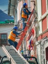 Quito, ECUADOR - 02 October 2019: Electricians are climbing on electric poles to install and repair power lines Royalty Free Stock Photo