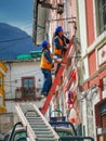 Quito, ECUADOR - 02 October 2019: Electricians are climbing on electric poles to install and repair power lines Royalty Free Stock Photo