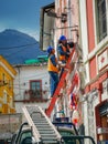 Quito, ECUADOR - 02 October 2019: Electricians are climbing on electric poles to install and repair power lines Royalty Free Stock Photo