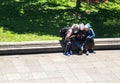 Quito, Pichincha, Ecuador, September 19, 2019. Three shoeshine boys sitting in a park looking at a cellphone