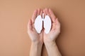 Quitting smoking concept. Woman holding paper lungs on beige background, top view