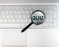 Quiz word through magnifying lens on laptops keyboard