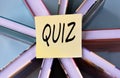 QUIZ - word on a yellow piece of paper on the background of books