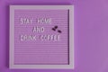 Quote stay home and drink coffee on purple decorative board. decoratin with coffee beans. Typography board for interior decoration