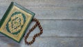 Quran and beads on wooden table