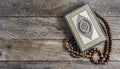 Quran and beads on wooden table