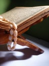 Quran-holy book of Muslims, an open book on rehal or wooden book rest with tasbih or islamic prayer beads Royalty Free Stock Photo