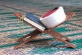 Quran, imam fez and rosary beads on a wooden stand in mosque. Royalty Free Stock Photo