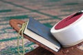 Quran, imam fez and rosary beads on a wooden stand in mosque. Royalty Free Stock Photo