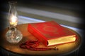 Quran, rosary beads and oil lamp on a wooden stand. Royalty Free Stock Photo