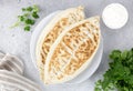 Qutab with green and sour cream or yogurt on gray background. Azerbaijani flat bread with greens.