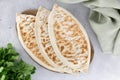 Qutab with green and sour cream or yogurt on gray background. Azerbaijani flat bread with greens. Top view.