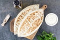 Qutab with green, sour cream or yogurt on gray background. Azerbaijani flat bread with greens. Top view, copy space.