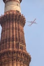 Qutub Minar tower with airplane in the sky, Delhi, India Royalty Free Stock Photo