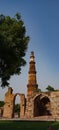 Qutub Minaret and many ruins with a tree in frame.