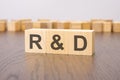 R and D text on wooden blocks. wooden background. foreground