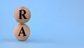 RA acronym on wooden balls on a blue background Royalty Free Stock Photo