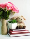 Rabbit doll sitting on notebook with artificial of green plant still life Royalty Free Stock Photo