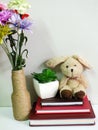 Rabbit doll sitting on notebook with artificial of green plant still life Royalty Free Stock Photo