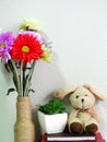 Rabbit doll sitting on notebook with artificial of green plant still life Royalty Free Stock Photo