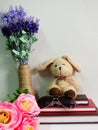 Rabbit doll sitting on notebook with artificial of green plant still life Royalty Free Stock Photo