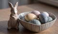 A rabbit figurine is sitting on a table next to a bowl of eggs Royalty Free Stock Photo