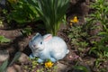 Rabbit garden figurine under a bush