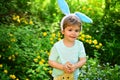 Rabbit kid with bunny ears. Hare toy. Little boy child in green forest. Egg hunt on spring holiday. love easter. Family Royalty Free Stock Photo