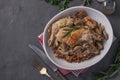 Rabbit meat with buckwheat, mushrooms and sour cream sauce in plate on a dark gray background. Copy space